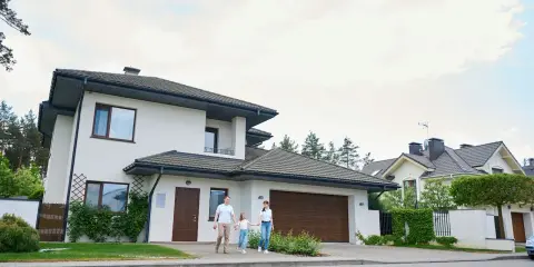 Rodzina spaceruje przed nowoczesnymi projektami domów piętrowych.