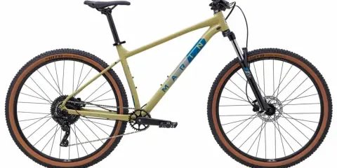 Beżowy rower trailowy Marin z brązowymi oponami WTB Trail Boss gotowy na podbój górskich ścieżek.