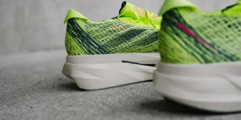 Leuchtend gelbe, fast verbotene Laufschuhe mit dunklen Streifen und einer dicken Sohle.