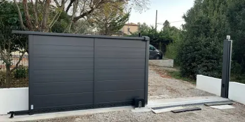 Emplacement moteur portail coulissant installé sur une nouvelle installation. Le portail est gris anthracite, moderne.
