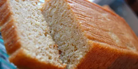 Un délicieux gâteau banane sans sucre, moelleux et doré, coupé en deux pour révéler sa mie aérée. Parfait pour un goûter sain.