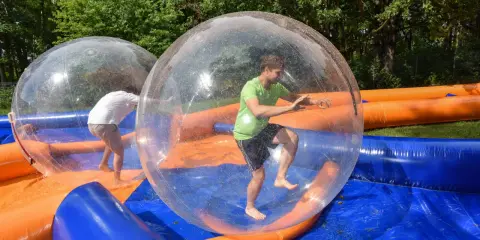 Świetne pomysły na team building: ludzie w dmuchanych kulach na wodzie, śmiech i zabawa gwarantowane!