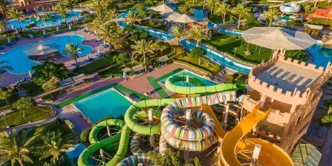 Wodne szaleństwo w Akassia Swiss Resort! Kolorowe zjeżdżalnie, baseny i palmy tworzą idealne miejsce na wakacje.