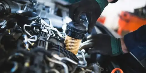 Mechanik wymienia filtr paliwa. Objawy jego zużycia mogą być różne, od spadku mocy po problemy z uruchomieniem silnika.