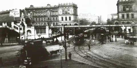 Straßenbahn und Pferdegespanne beleben eine geschäftige Stadtkreuzung, ein Zeichen für den wachsenden urbanisierungsgrad deutschland.