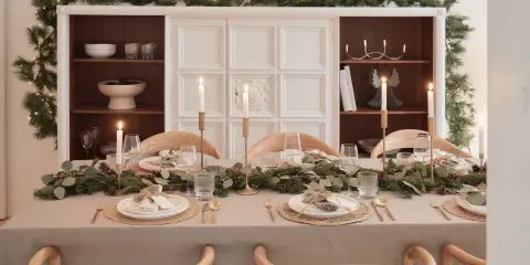 Elegancko nakryty stół na Boże Narodzenie z girlandą z gałązek, świecami i złotymi sztućcami. Inspiracja, jak udekorować stół na Boże Narodzenie.