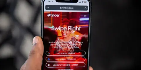 Ekran logowania Tindera z opcjami "Swipe Right", "Log in with Google", "Log in with Facebook" i "Log in with phone number". Szybkie skróty na Tinderze ułatwiają rozpoczęcie randkowania.