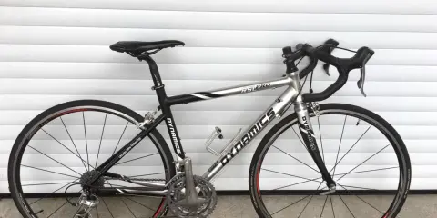 Silbernes Rennrad DYNAMICS RSL COMP mit schwarzen Akzenten, bereit für die nächste Fahrt.