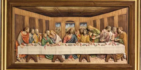 Relief sculpté de la Cène, montrant Jésus et ses disciples autour d'une longue table. Les personnages sont représentés avec des expressions variées.