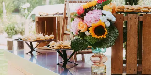 Un buffet de mini-burgers et un bouquet coloré, une belle idée apéro mariage en plein air.