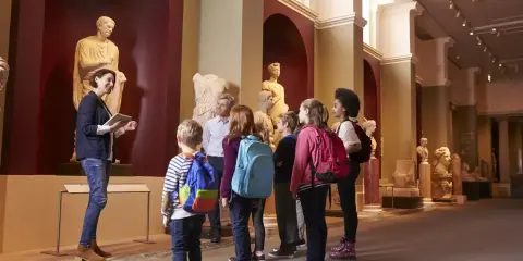 Un grupo de niños disfruta de las exposiciones en un museo de Madrid, aprendiendo sobre arte e historia con su guía.
