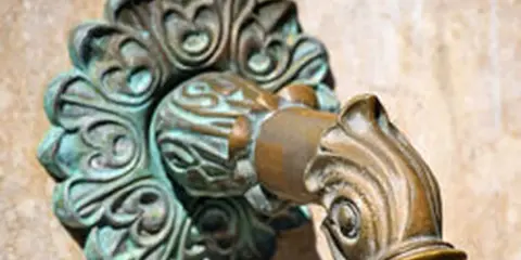 Robinet en laiton orné, avec des traces de vert-de-gris.