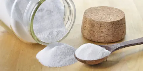Bicarbonate de soude, une solution naturelle pour le traitement de l'oïdium. Une cuillère en bois et un pot renversé en témoignent.