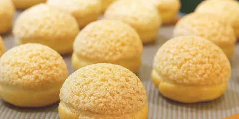 Une rangée de craquelins choux dorés et croustillants, prêts à être dégustés.
