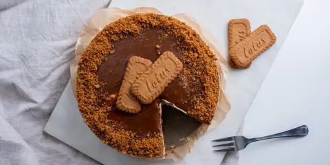 Pyszny sernik lotus bez pieczenia, ozdobiony ciasteczkami Lotus i pokruszoną bazą. Idealny deser dla miłośników karmelowych smaków.