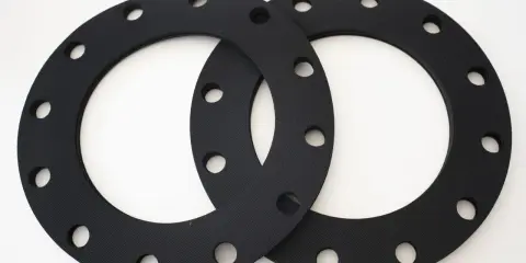 Deux joints sbr noirs, circulaires et percés, prêts à assurer l'étanchéité d'une connexion.