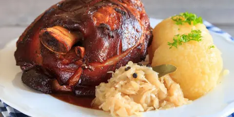Knusprige Schweinshaxe mit Klößen und Sauerkraut. Ein köstliches Schweinshaxe Rezept für Genießer.