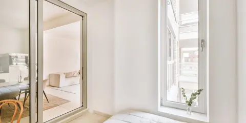 Puerta corredera de cristal que da a un salón. Explora los tipos de cristales para puertas de interior y cómo iluminan tu hogar.