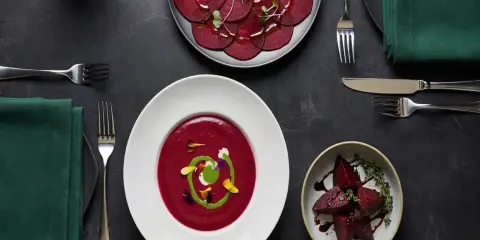 Un repas gastronomique met en vedette la betterave rouge sous diverses formes : en carpaccio, en velouté onctueux et en morceaux rôtis.