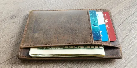 Brązowy, skórzany portfel z kartami i banknotami. Dowiedz się, jak wyczyścić skórzany portfel, by wyglądał jak nowy.