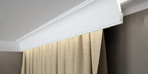 Elegancki montaż maskownicy karnisza z ukrytym oświetleniem LED. Zasłony w beżowym kolorze dodają przytulności.