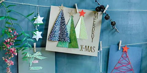 Selbstgebastelte Weihnachtskarten mit Bäumen, Sternen und Schriftzug "Merry X-Mas".