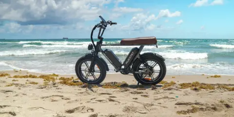 Schwarzes E-Bike am Strand. Die Frage "wieviel Watt sollte ein E-Bike haben?" beschäftigt viele. Dieses Modell ist bereit für Abenteuer.