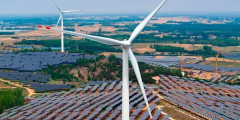 Große Windturbinen und weite Felder von Solarmodulen zeigen Chinas Engagement für erneuerbare Energien.