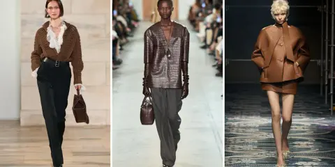 Modelli sfilano con outfit in colore testa di moro, mostrando abbinamenti eleganti con pantaloni neri, grigi e completi in pelle.