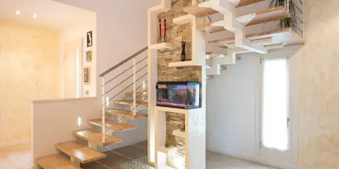 Moderna scala interna in legno e metallo con acquario integrato. Il design innovativo suggerisce un interessante costo scala interna.