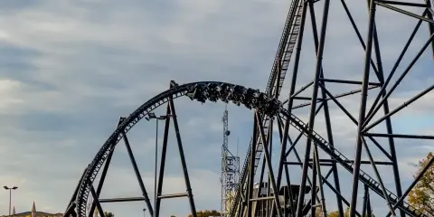 Pasażerowie jadą na wagonikach największego rollercoastera w Europie, który pnie się po stalowej konstrukcji.