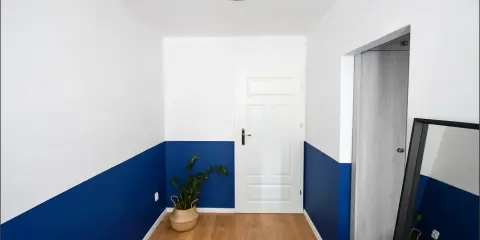 Nowoczesny korytarz z dwukolorową lamperią. Zobacz, jak pomalować lamperie w ciekawy sposób, tworząc geometryczne wzory.