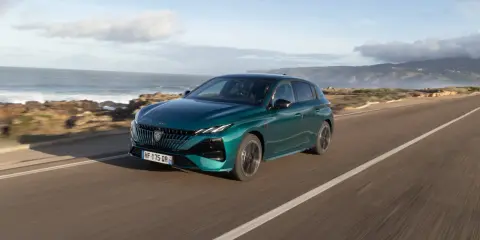 Zielony Peugeot 308 jedzie wzdłuż malowniczego wybrzeża.