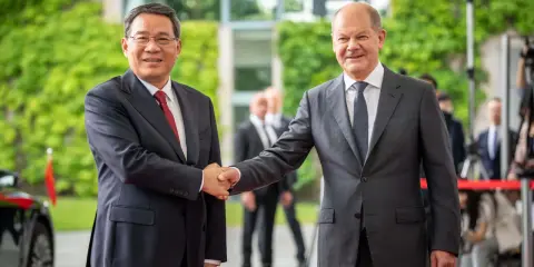 Zwei Männer schütteln sich die Hände. Im Hintergrund grüne Pflanzen und Gebäude. Ein Treffen, das die Weichen für eine gemeinsame Zukunft in Sachen China Nachhaltigkeit stellen könnte.