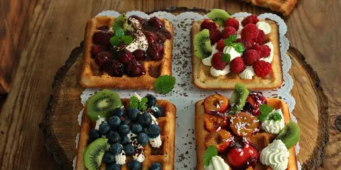Pyszne gofry belgijskie z owocami: malinami, borówkami, kiwi i śliwkami. Idealne na deser, gdy szukasz inspiracji na gofry belgijskie przepis.
