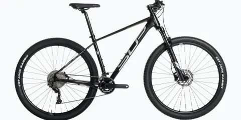 Czarny rower górski, idealny do wyścigów mtb xc. Wyposażony w amortyzator, przerzutki i opony CST Jack Rabbit.