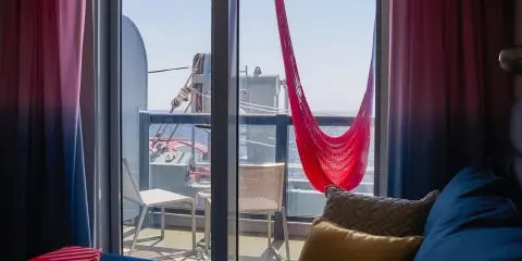 Cabina balcone vista parziale MSC con amaca rossa e cuscini accoglienti.