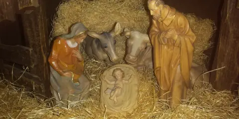 Szopka z figurkami: Maryja, Józef, Dzieciątko Jezus, wołek i osiołek. Tekst opowiada o narodzinach.