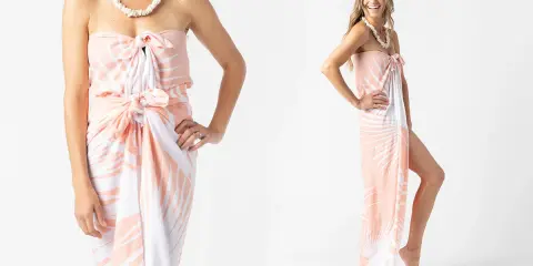 Modella mostra come indossare un pareo con fantasia tropicale, annodato in vita e al seno, con una collana di conchiglie.