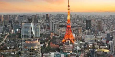 Widok na Tokio, największe miasto na świecie, z wieżą Tokyo Tower w pomarańczowych barwach o zachodzie słońca.