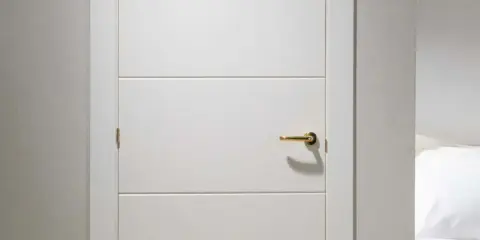Puerta lacada en blanco con tirador dorado. Aprende como limpiar puertas lacadas en blanco para mantenerlas impecables.