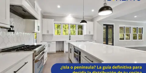 Cocina moderna y luminosa con una espaciosa isla central, gabinetes blancos y electrodomésticos de acero inoxidable.