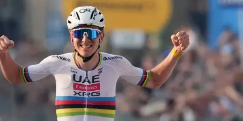 Jubelnder Radfahrer im UAE-Trikot, die Arme erhoben. Sein Erfolg spiegelt sich im hohen Pogacar Gehalt wider.