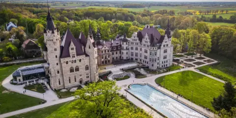 Zamek Moszna, jedna z największych atrakcji Opolszczyzny, z imponującą architekturą i rozległym parkiem z fontanną.