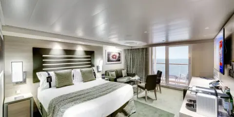 Lussuosa cabina nave con letto king-size, divano, balcone vista mare e TV.