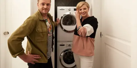 Para prezentuje pralkę i suszarkę w kuchni.