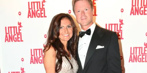 Gunilla von Platen med sin partner framför en vägg med texten "Little Angel".