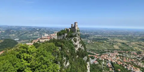 Widok na San Marino z zamkiem na skale. Idealne miejsce, by sprawdzić, jak dojechać z Rimini do San Marino.