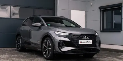 Grauer Audi q4 e tron steht vor einer Garage.