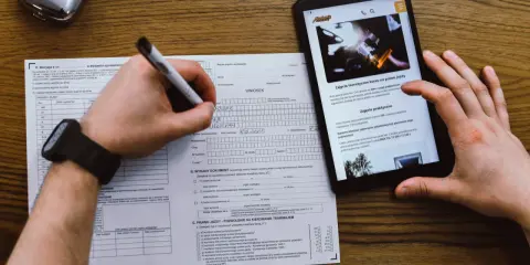 Wniosek o prawo jazdy, kurs na prawo jazdy online. Dokumenty i tablet z informacjami o kursach.